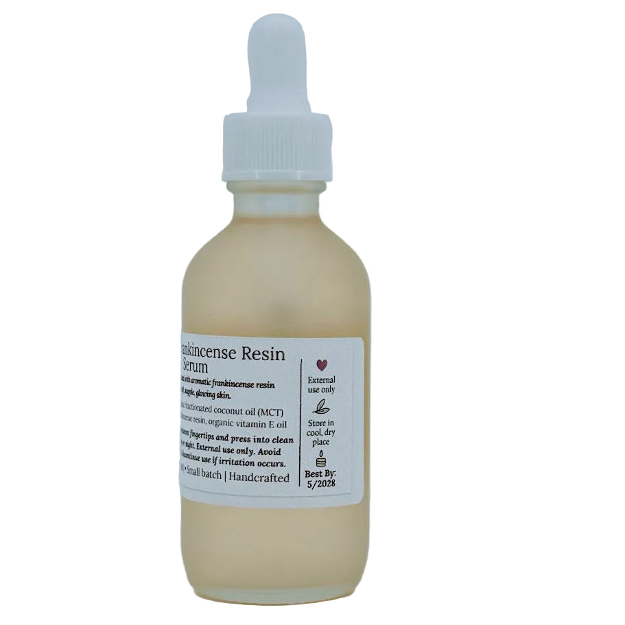 Glass dropper bottle of MCT & Frankincense Serum from The Homemaker’s Hustle. The label includes a farmhouse illustration and text describing a silky serum infused with frankincense resin. Net weight 2 oz.