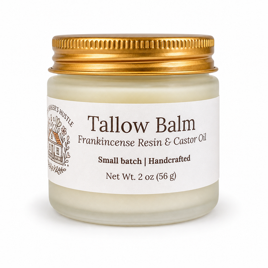 Frosted glass jar of tallow balm with frankincense resin and castor oil and gold lid on white background