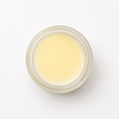 An flat lay photo of an open jar of tallow balm