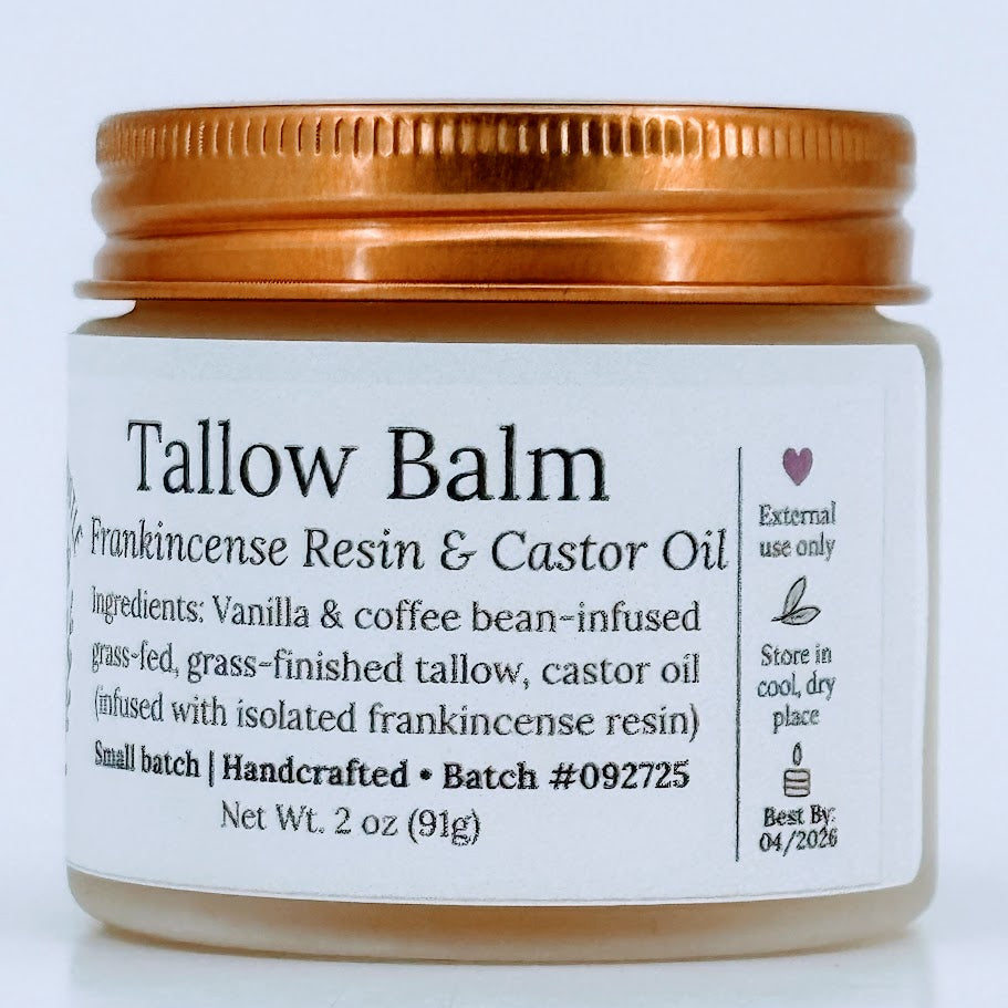 Glass jar of Tallow Balm with a copper-colored metal lid. The label reads ‘Tallow Balm – Frankincense Resin & Castor Oil’ and lists ingredients including vanilla- and coffee-bean-infused grass-fed tallow and castor oil. Net weight 2 oz.